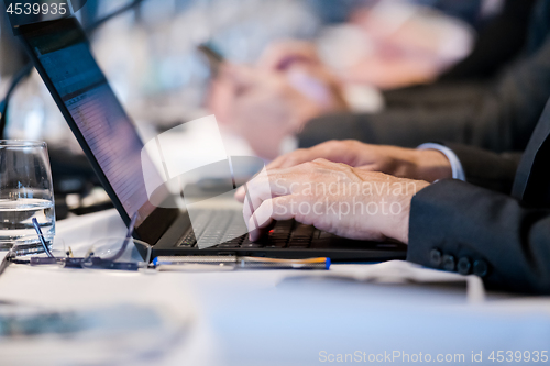 Image of close up of business people hands using laptop computer