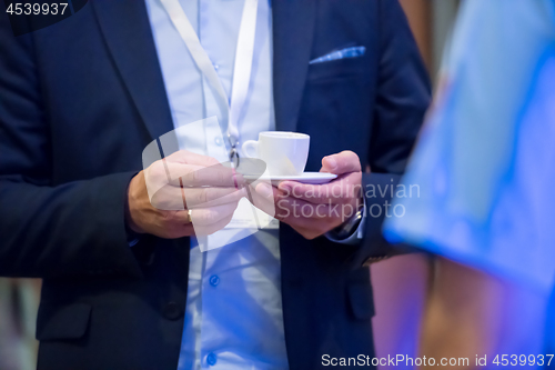 Image of closeup of businessman holding a cup of coffee