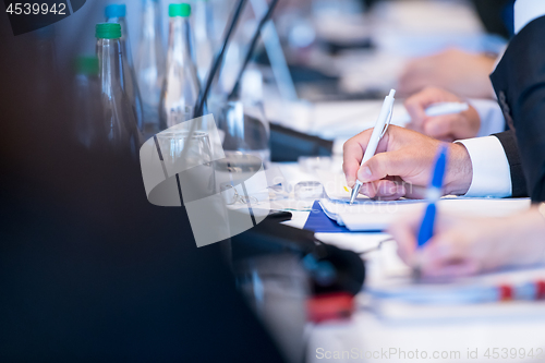 Image of close up of business people taking notes