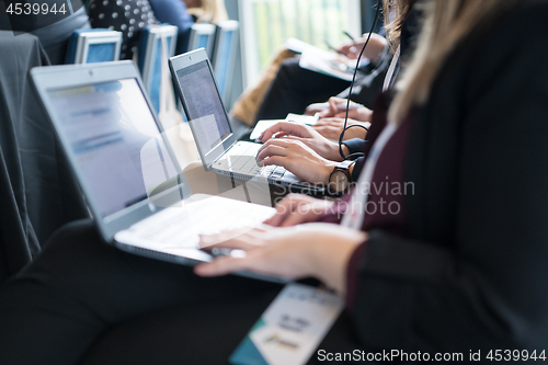 Image of close up of business people hands using laptop computer