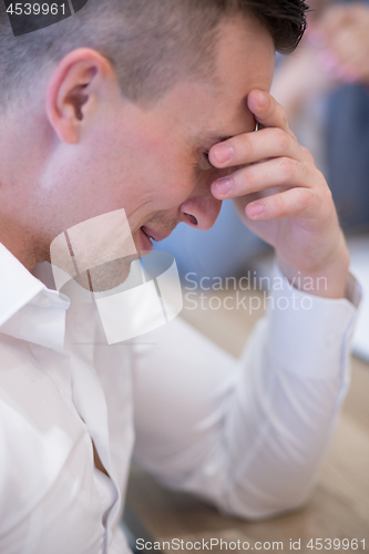 Image of young businessman relaxing at the desk