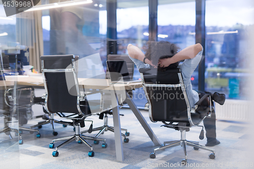 Image of young businessman relaxing at the desk