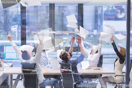 Image of startup Group of young business people throwing documents