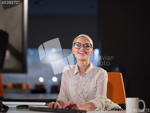 Image of woman working on computer in dark office