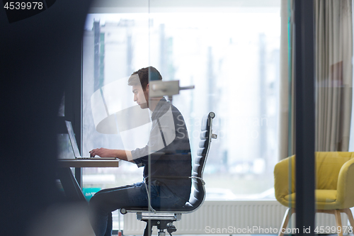 Image of businessman working using a laptop in startup office