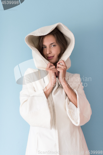 Image of woman in a white coat with hood isolated on blue background