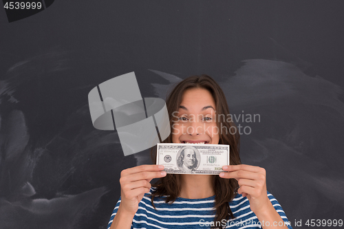 Image of woman holding a banknote in front of chalk drawing board