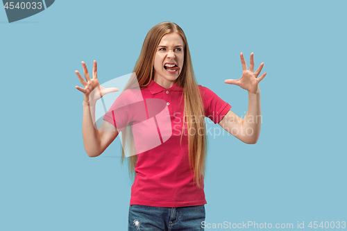 Image of Portrait of an angry woman looking at camera isolated on a blue background