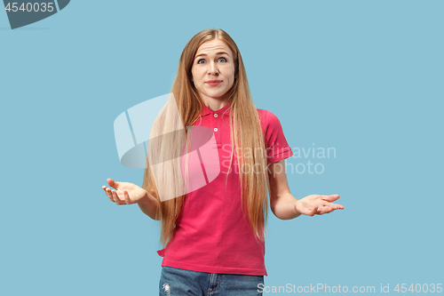 Image of Beautiful woman looking suprised and bewildered isolated on blue