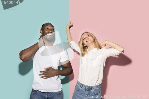 Image of happy afro man and woman. Dynamic image of caucasian female and afro male model on pink studio.