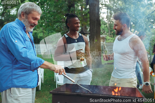 Image of Group of friends making barbecue in the backyard. concept about good and positive mood with friends