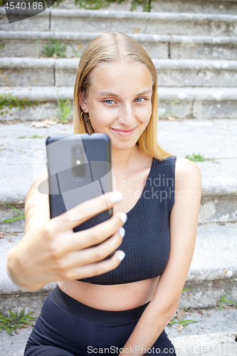 Image of Attractive young woman in black taking selfie.