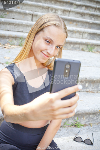 Image of Attractive happy young woman taking selfie.