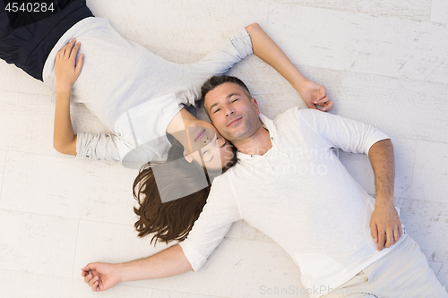 Image of handsome couple lying on floor