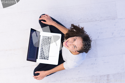 Image of women using laptop computer on the floor top view
