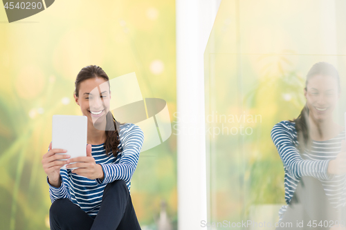 Image of young women using tablet computer on the floor