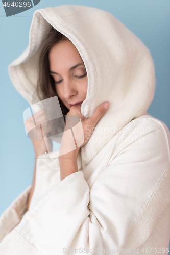 Image of woman in a white coat with hood isolated on blue background