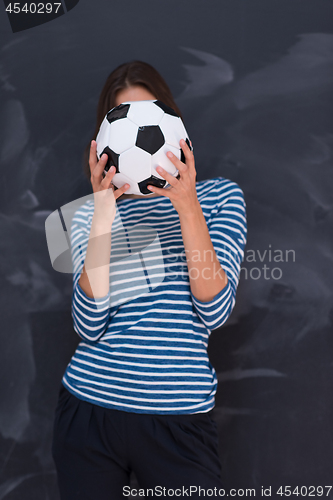Image of woman holding a soccer ball in front of chalk drawing board