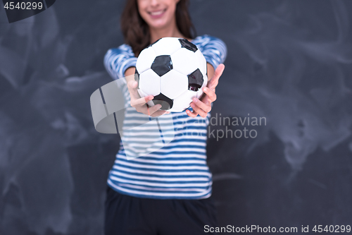 Image of woman holding a soccer ball in front of chalk drawing board