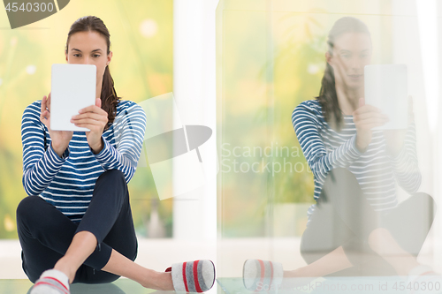 Image of young women using tablet computer on the floor