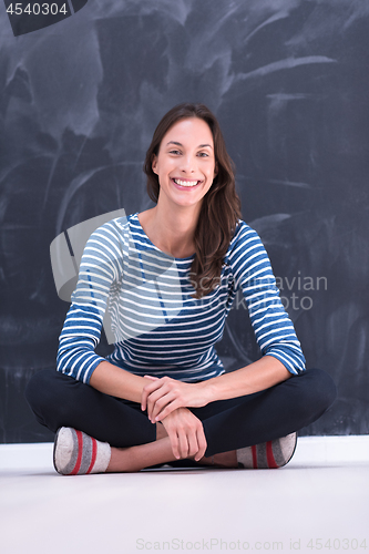 Image of woman sitting in front of chalk drawing board