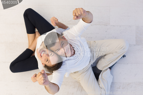 Image of couple sitting with back to each other on floor