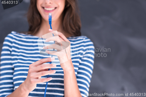 Image of woman holding a internet cable in front of chalk drawing board