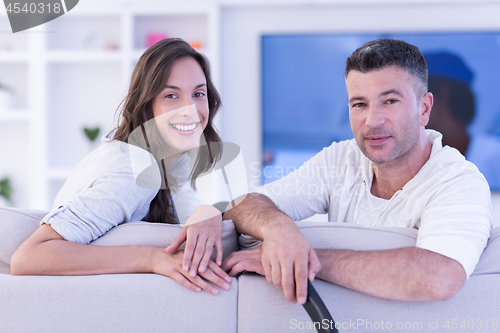 Image of Young couple on the sofa watching television