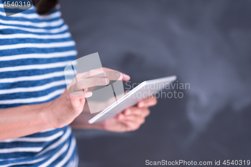 Image of woman using tablet  in front of chalk drawing board