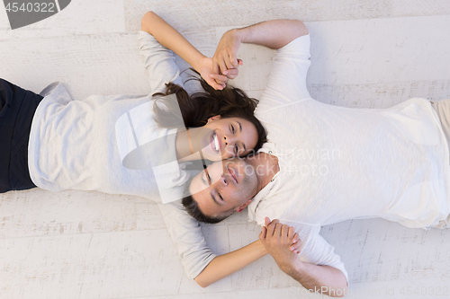 Image of handsome couple lying on floor