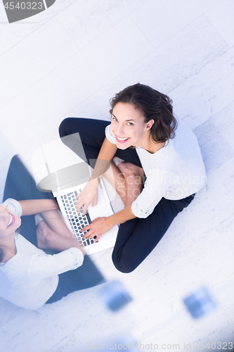 Image of women using laptop computer on the floor top view