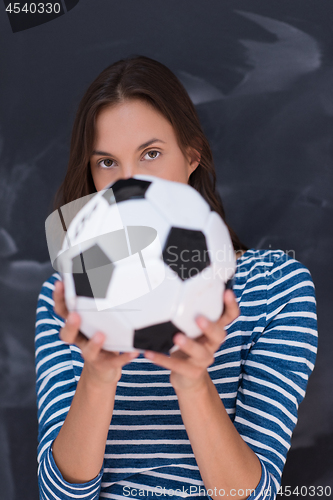 Image of woman holding a soccer ball in front of chalk drawing board