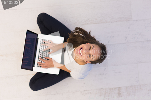 Image of women using laptop computer on the floor top view