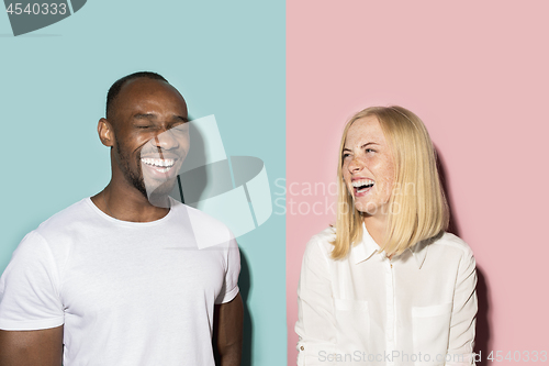 Image of happy afro man and woman. Dynamic image of caucasian female and afro male model on pink studio.