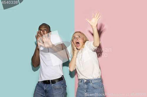 Image of Portrait of the scared couple on pink and blue studio background