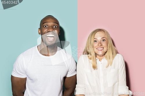 Image of happy afro man and woman. Dynamic image of caucasian female and afro male model on pink studio.