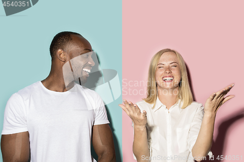 Image of happy afro man and woman. Dynamic image of caucasian female and afro male model on pink studio.