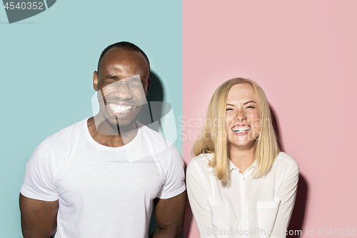 Image of happy afro man and woman. Dynamic image of caucasian female and afro male model on pink studio.