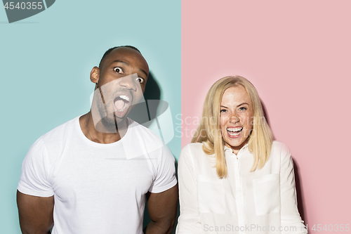 Image of happy afro man and woman. Dynamic image of caucasian female and afro male model on pink studio.