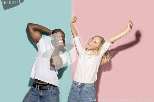 Image of The squint eyed couple with weird expression on blue and pink studio