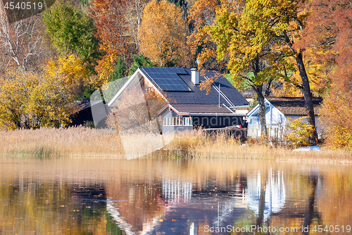 Image of house at the lake with solar panels on the roof