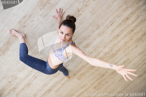 Image of Fit sporty active girl in fashion sportswear doing yoga fitness exercise in yoga studio. Active urban lifestyle.