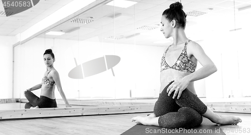 Image of Fit sporty active girl in fashion sportswear doing yoga fitness exercise in in yoga studio.