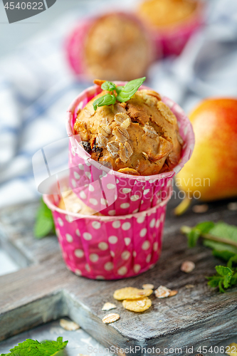 Image of Freshly baked muffins with pear in paper forms.