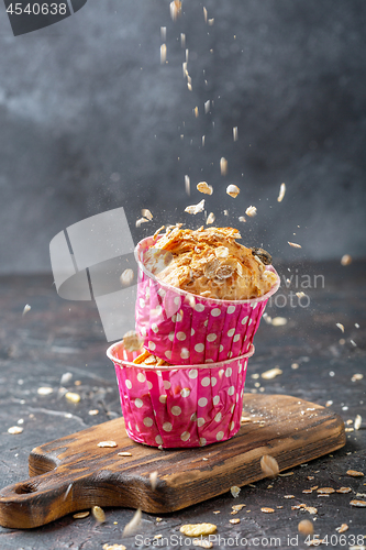 Image of Muffins with pears and muesli in pink paper forms.