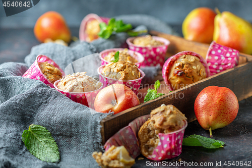 Image of Muffins with pears and muesli in a wooden tray.