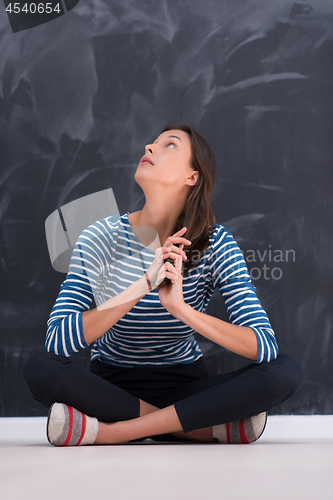 Image of woman sitting in front of chalk drawing board