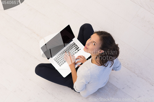 Image of women using laptop computer on the floor top view