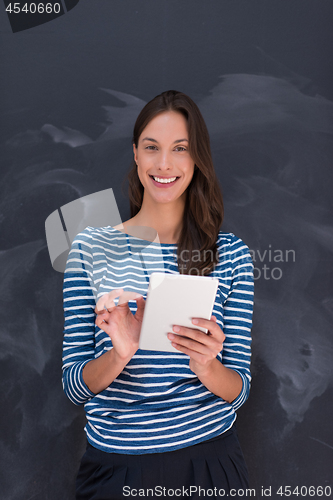 Image of woman using tablet  in front of chalk drawing board