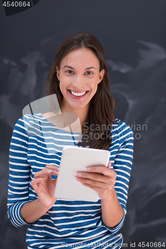 Image of woman using tablet  in front of chalk drawing board